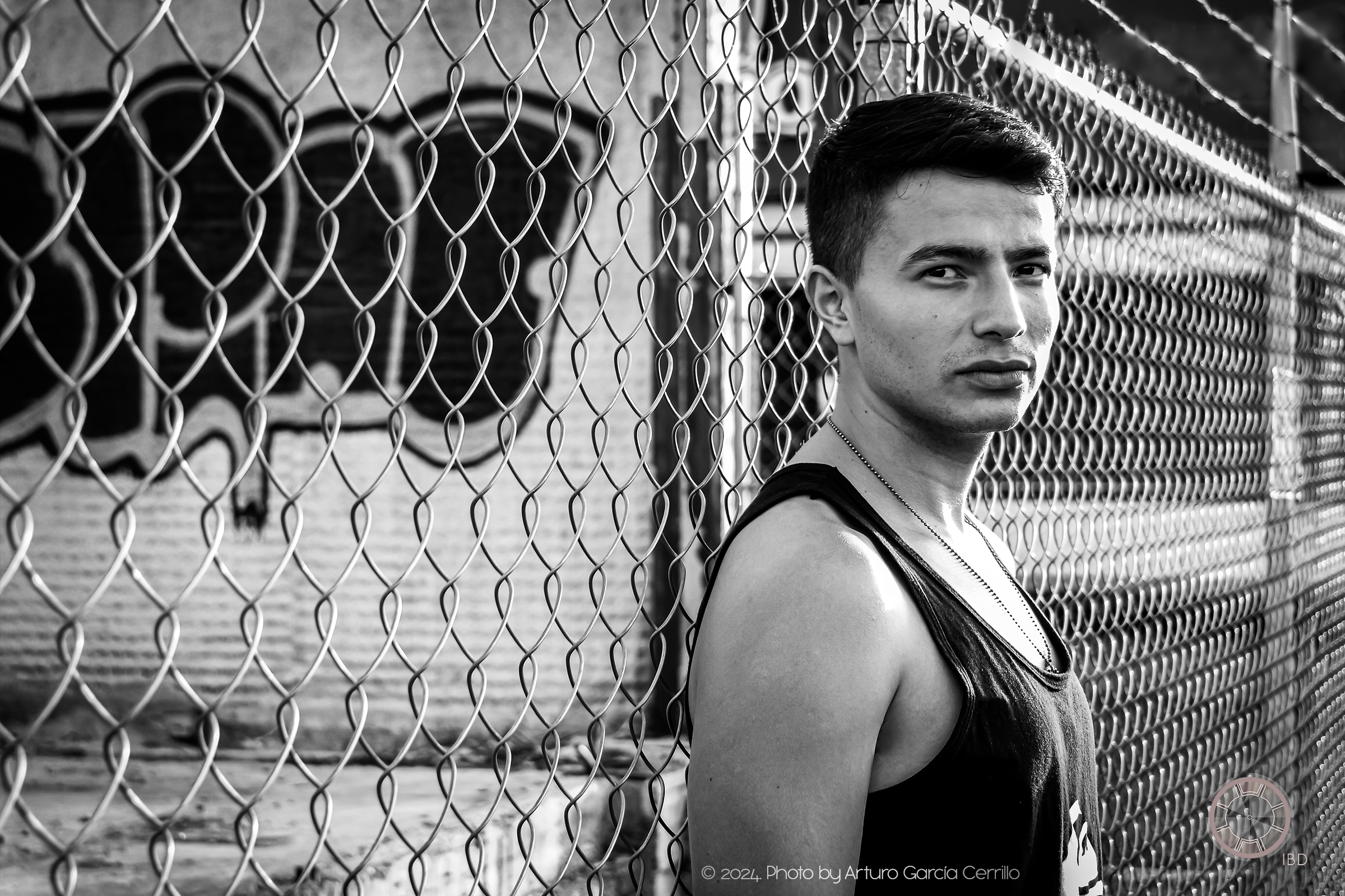 Portrait of guy posing for this scene laying on wire fence