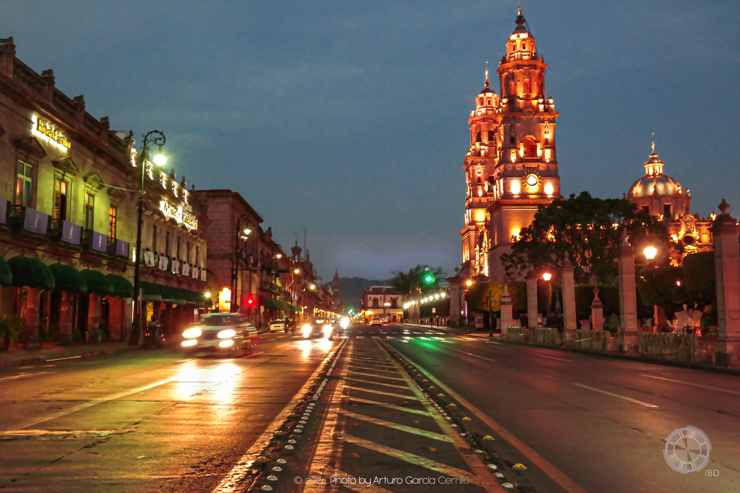 Picture of main Morelia's downtown avenue. Taken at dusk showing the Cathedral and cars passing by.