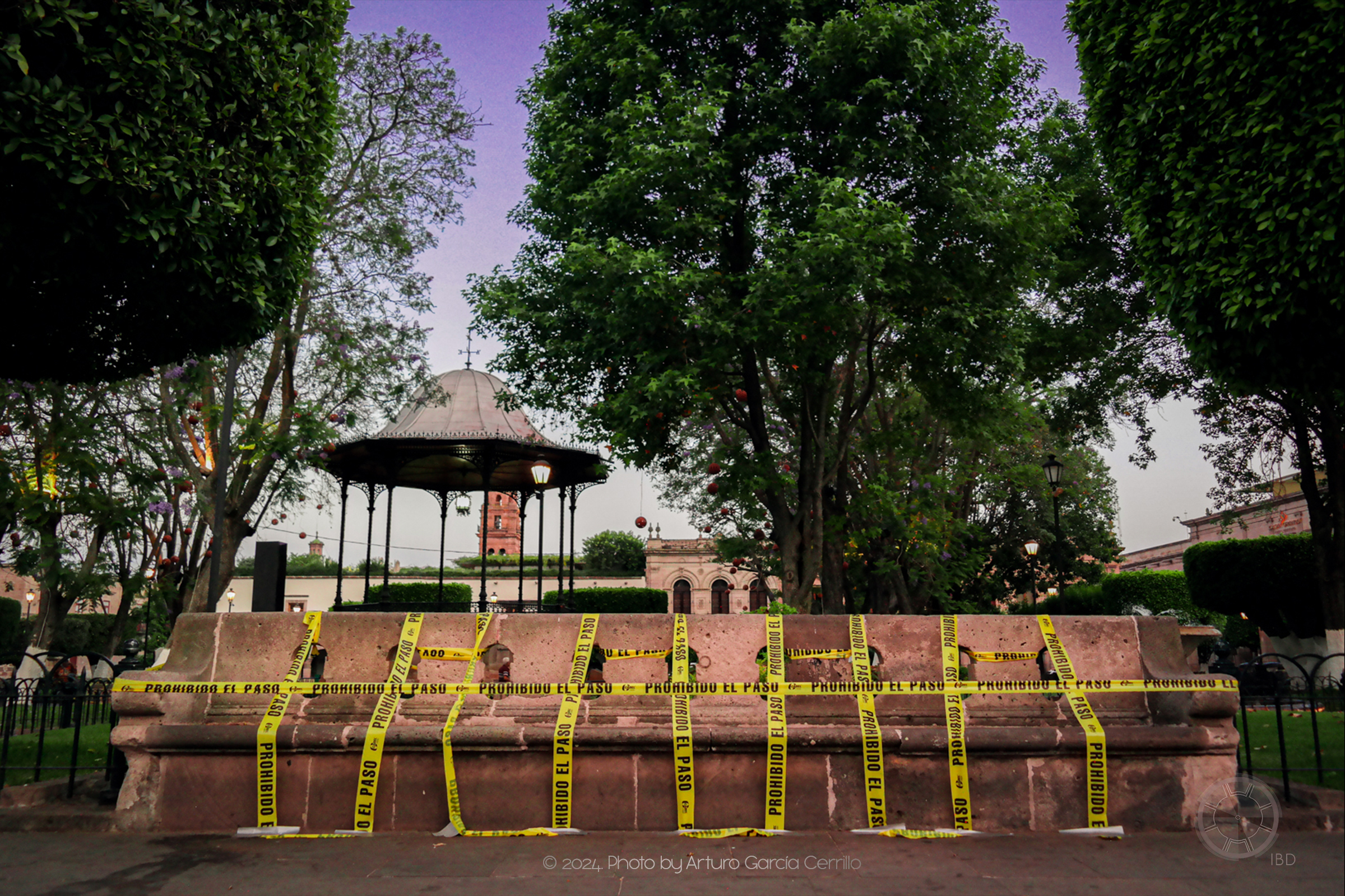 Picture of stone bench restricted with caution tape at sunset