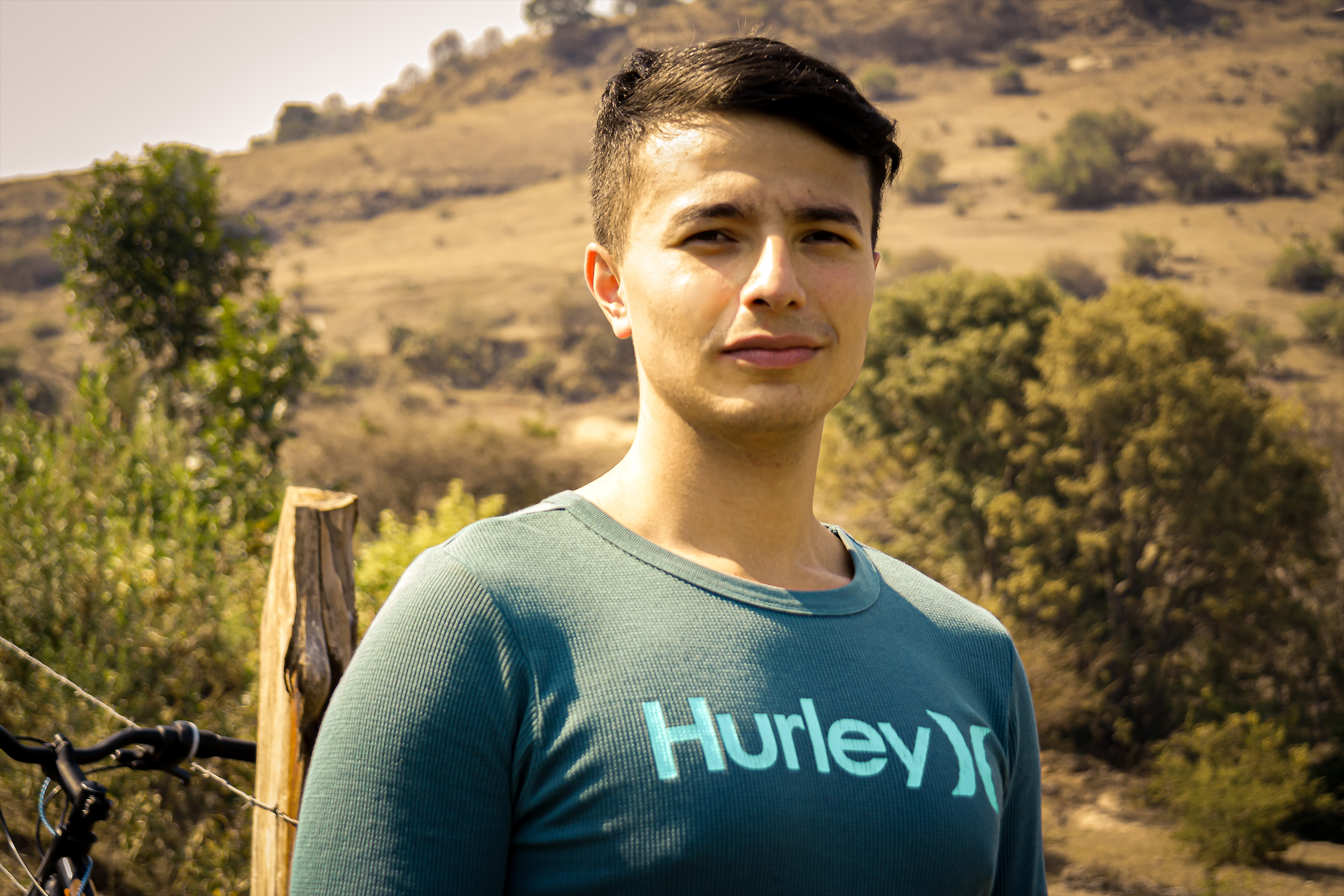 Side portrait of smiling young man posing for picture in high temperature environment